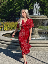 a lady in a red dress with white polka dots
